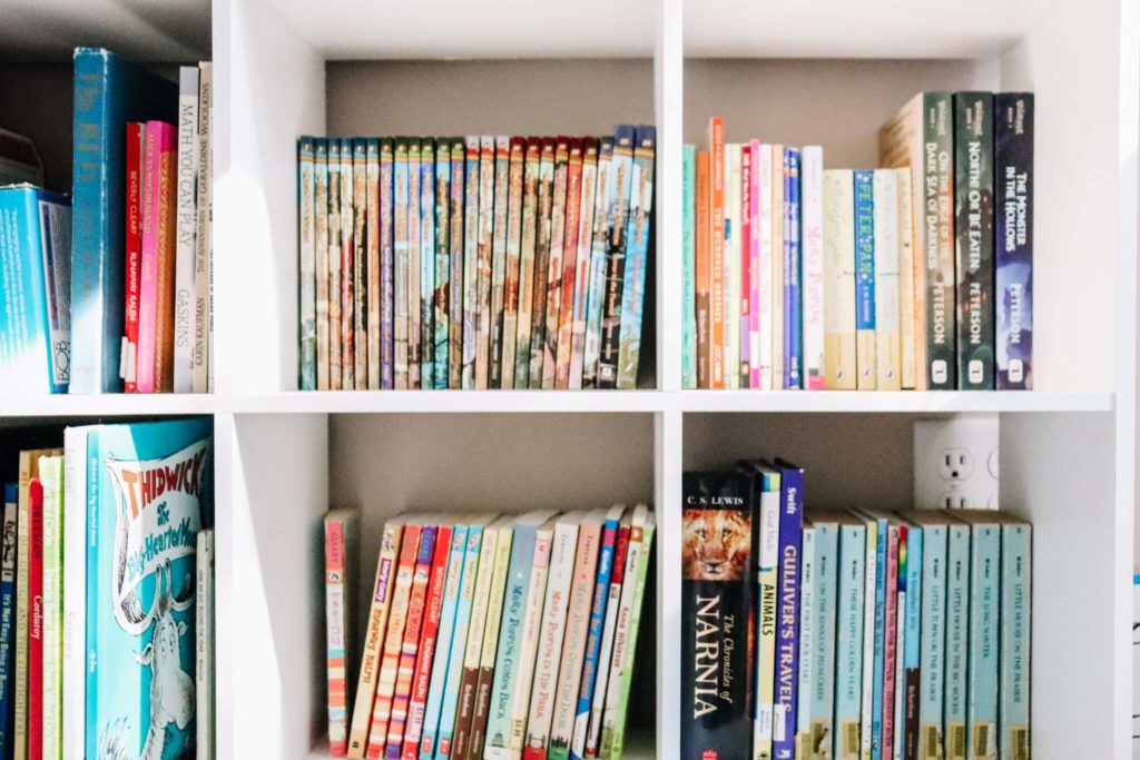 A white bookshelf full of books for children to read